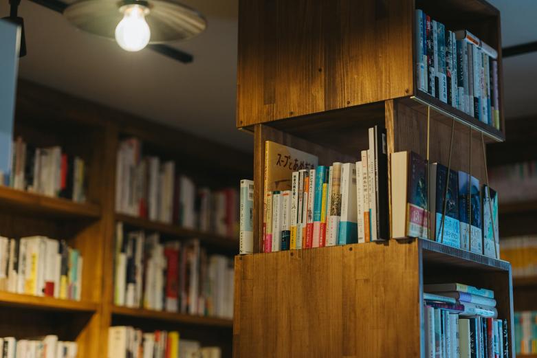 <span style="font-size:12px;"><font color="ffffff"> 店内にはおよそ4000冊の本が並びます。<br> <br> ただ、本屋をずっと見続けてきたからこそ、後藤さんには「本屋だけでは、いずれ立ちゆかなくなる」という危機感がありました。本屋と組み合わせられる何か。その答えがカフェだったのです。<br> <br> 「本が好きな人だけにしぼりこんでしまうと店としての間口は狭くなってしまいますよね。本が好きではない人にとっても、来たくなる場所。そんな店をつくりたかったんです。来店してもらうことで、ゆるやかに本との接点がつくれますから」</font></span><br><br>