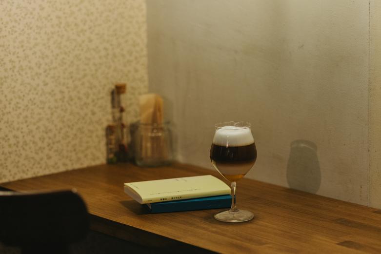 <span style="font-size:12px;"><font color="ffffff">はちみつのやわらかな甘さがミルクの風味とともに体にすっと溶け込んでいく人気コーヒー「ハニー・カフェ・コン・ レーチェ」。４層仕立てで見た目にもキュートです。<br> <br> 販売するのは、新刊のみ。後藤さんの目利きが光るセレクトに思わず目が止まり、手が伸びます。<br> <br> 「固定のジャンルに特化しているということではありませんが、海外文学と歌集、あとはエッセイに力を入れています。最近は短歌の本が売れていて、お客様に僕の気持ちが届いているように思え、うれしいですね。でも、歌集は本当に好きなジャンルなので、売れなくても置き続けたいと考えていますよ。逆にどんなに売れるとしてもビジネス本は置かないですね。この店では仕事を忘れてほしいですから。自分で店をするって、きっと、そういうことでしょ」<br> <br> 基本的には毎日22時まで営業。水曜は特別に24時まで営業時間を延長し、グランドメニューのほかに、スープが品書きに加わります。<br> <br> 「僕がお酒も好きなもので、ついついメニューも増えてしまって。夜は飲みながら本を味わってほしいですね」と笑顔を見せる後藤さん。お酒好きにとっても、至福の夜喫茶タイムになること間違いなしです。</font></span><br><br>