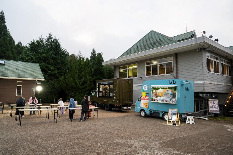 <span style="font-size:12px;">キッチンカーなども登場しているのでゆっくり過ごせます<br><br>当日は18時から入園受付がスタート。小雨でも決行されるので、「ちょっと天気が心配…」なんて日でも大丈夫。園内に一歩足を踏み入れると、昼とはまるで別世界。日中に咲き誇っていた花々がやわらかな光に包まれ、幻想的なナイトガーデンへと姿を変えます。<br><br>芝生エリアもあり、シートを広げて寝転ぶ人たちの姿もちらほら。涼しい夜風に吹かれながら、空が少しずつ群青色に染まっていくのを眺めていると、それだけで胸が高鳴ります。やがて訪れる“光の瞬間”を待つ時間も、このイベントの楽しみのひとつです。</span><br><br>