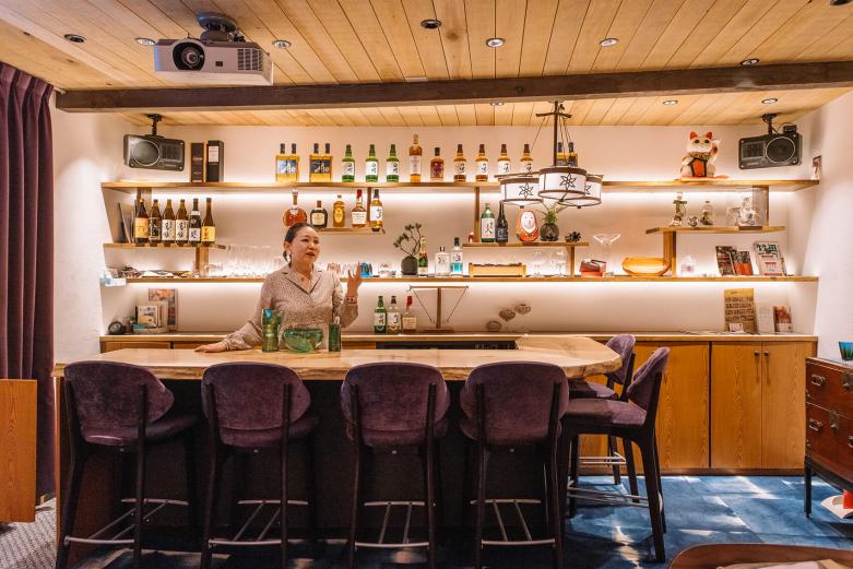 <span style="font-size:12px;"><font color="ffffff"> ２軒目は、田町通りに戻って〈スナック jolie &amp; はた〉へ。<br> <br> 「スナックに行ったことがない人でも十分楽しめるはたさんの懐の広さと明るさが魅力」という堀場夫妻。<br> <br> ママであるはたきみよさんの持ち味は、幅広い層のお客さまを楽しませてくれる明るい接客。「はたさんのキャラクターをわかっているから、cueのゲストを安心して送り出せる」というのもうなづけます。</font></span><br><br>