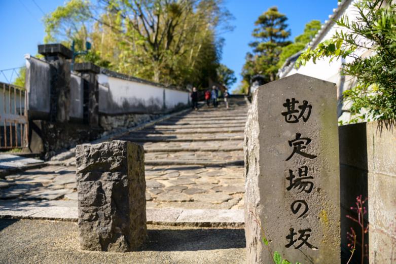 杵築の町を物語るのが「坂」です。まずは、杵築城から北台武家屋敷を結ぶ「勘定場（かんじょうば）の坂」へ。坂の上からは、杵築城の天守閣が見えます。