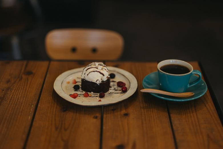 <span style="font-size:12px;"><font color="ffffff">好きなスイーツを選べる「ケーキセット」の一例。写真は「チョコのしっとりケーキ」。セットの場合、コーヒーは野尻さんが最初につくり上げたオリジナルブレンド「1」になります。<br> <br> そんな野尻さんに転機が訪れます。それが焙煎。これまでコーヒーが苦手だった人生を歩んできた野尻さんでしたが、自分で豆を焼き、試飲するようになると、時折、好きな味のするコーヒーに出合うようになります。<br> <br> 「コーヒーは豆自体の味の違いだけでなく、煎り方でがらりと風味が変化することを知ったんです。私が苦手だったのは酸味の強い味だったので、浅煎りではなく、中煎りや深煎りでローストして苦味を加えることで、心から『おいしい！』と思える味になりました。『自分が好きなコーヒーをつくろう』と試行錯誤しているうちに、どんどんコーヒーの魅力にのめり込んでいったんです」</font></span><br><br>