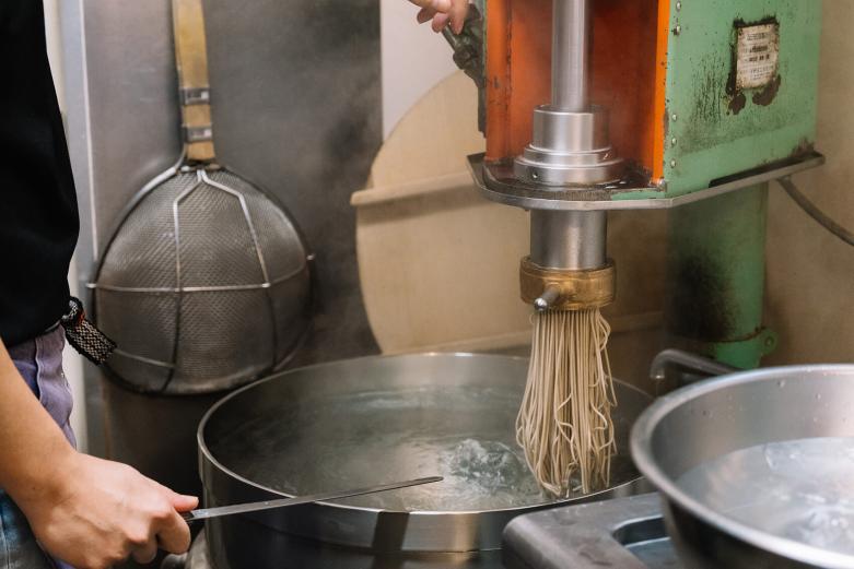 <span style="font-size:12px;">まずは人気の別府冷麺から。<br> オーダーを受けてから製麺機で麺を絞り茹でていきます。<br> 小麦粉、そば粉、でん粉、塩のみのシンプルな材料でできた自家製麺と、昆布と牛スネなどをじっくり煮込み醤油をブレンドしたオリジナルのスープが特徴です。<br> なんでもご主人はラーメン店などで一度も修行をしていないそう。これまで食べた別府冷麺の味を思い出し忠実に再現しようと、妥協せずおいしさを追求してこられたのだといいます。</span><br><br>