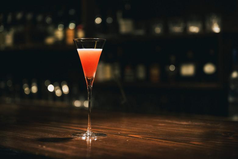 <span style="font-size:12px;">りんごからつくられるブランデー「カルヴァドス」を使ったショートカクテル「ジャック・ローズ」1300円。<br> <br> 心地よく響くイタリアオペラの音楽と煙を感じながら、静かな酔いに身を任せれば、ここが歓楽街のど真ん中であることをつい忘れてしまいそう。オープン直後から席が埋まり出すので、気兼ねなくゆっくり過ごすなら深夜の時間帯がおすすめです。たまにはこんな非日常の空間を楽しむのもいいのではないでしょうか。</span><br><br>