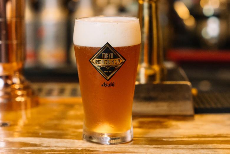 <span style="font-size:12px;"><font color="ffffff"> とはいえせっかくなので、マスターの小池広さんにおすすめのビールを聞いてみました。<br> <br> 「コロナ禍でだいぶ減ってしまったけど……」というラインナップのなかから、現在おすすめの〈隅田川ブルーイング ペールエール〉をいただくことに。<br> <br> 真剣な眼差しでビアサーバーからペールエールを注いだ後、ばっちりポーズを決めてくれたマスター。手渡された１パイントグラスに琥珀色が輝きます。華やかな香りと豊潤でフルーティーな味わいのペールエールに「くう〜」と唸る、至福の瞬間です。</font></span><br><br>