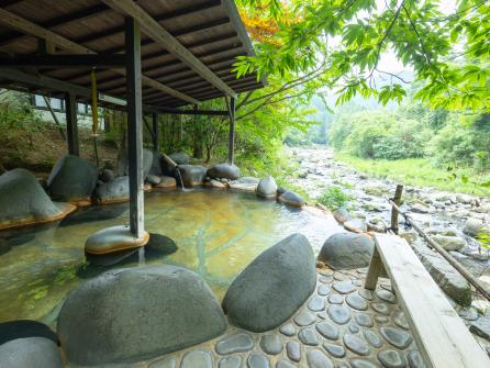 男性露天風呂には湯船が４つ。最上段の岩風呂からは川を見下ろす