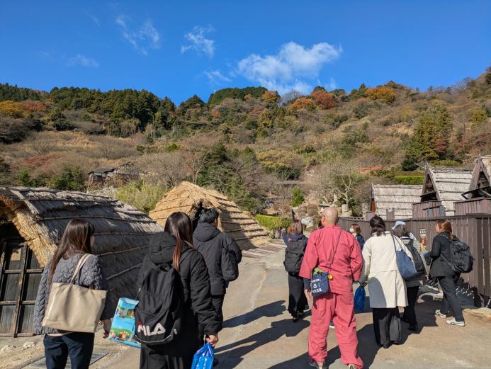 <span style="font-size:14px;">「湯の花」の歴史をしっかりと学んでから、いよいよ一湯目の入浴体験です。<br>『みょうばん湯の里』の大露天風呂は、標高350mの高台にあります。<br>風情ある「湯の花小屋」と、鮮やかに色づいた紅葉を眺めながら、ゆっくりと坂道を登っていきます。</span><br><br>