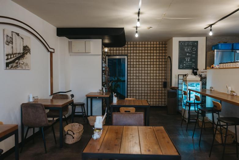 <span style="font-size:12px;"><font color="ffffff"> 入口側の壁に広がるタイルに一目惚れして、この物件に決めたという野尻さん。<br> <br> 野尻さんがこの自家焙煎のカフェ〈Coffee Shop haze〉を開業したのは13年前のこと。もともとは営業職のサラリーマンでした。<br> <br> 「実家が喫茶店をしていたので、コーヒーとは昔から縁があったのですが、私自身、ずっとコーヒーが好きではなくて」と苦笑い。そんななか、野尻さんの姉がカフェを独立開業することになり、ひょんなところからその立ち上げを手伝うことになりました。好きではないながらも、実際に店舗で体験することで、知識と経験を得ていきます。</font></span><br><br>