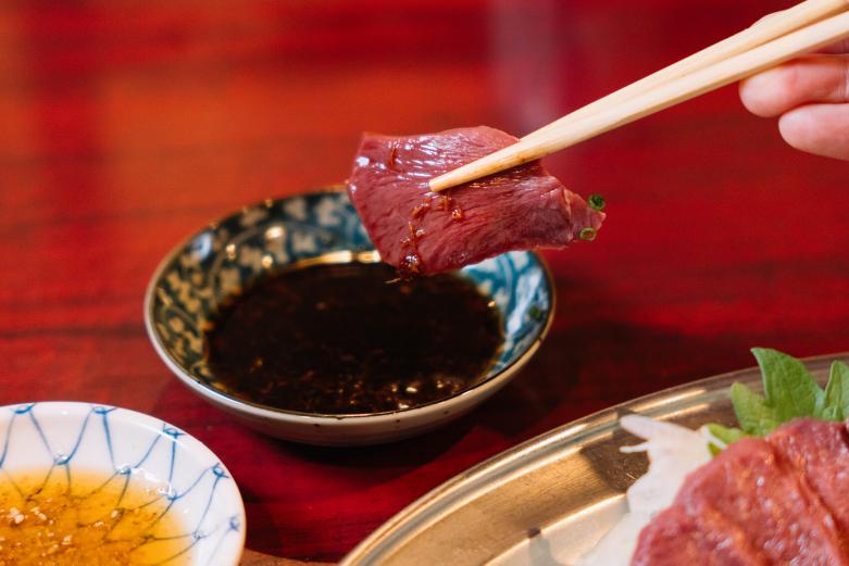 <span style="font-size:12px;">次にいただくのは心臓の部位である「シン」の刺身です。シン刺しには、生姜醤油とごま塩のタレが２種類。まずは生姜醤油をつけていただきます。<br> <br>しっかりとした歯応えがあるのにかたさはなく、赤身の他の部位よりさっぱりとした味わいです。「シン刺しってこんなにヘルシーなんだ」という驚きと、想像以上の新鮮さに目が覚めるほど！</span><br><br>