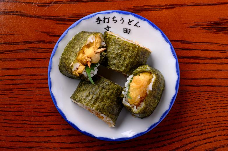 <span style="font-size:12px;"> さらに人気なのが、衣サクサク、しその風味がとりこになる「天まき」600円。<br>香ばしい天ぷらを巻いたお寿司で、持ち帰りもできるため、手土産やホテルでの夜食に購入する人も多いそうです。</span><br><br>