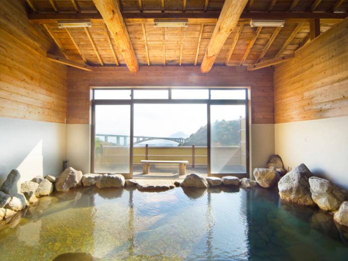 <font color="#800080"><strong>山の湯</strong></font><br>明礬の山あいにある山小屋風の温泉施設。大きな窓からはアーチ型の明礬橋や別府湾、高崎山が一望でき、天井も高く開放感たっぷり。白濁した湯には“湯の花”が浮かび、泉質の良さがうかがえる。湯上りには、向かいにある『岡本屋売店』の「元祖地獄蒸し®プリン」をぜひ。<hr><span style="font-size:14px;">【DATA】<br >・住所／別府市明礬1組<br>・電話／0977-66-5881<br>・種類／内湯、貸切湯<br>・泉質／単純温泉<br><a href=" https://jigoku-prin.com/hotspring/ " target="_blank"><font color="#0033ff">詳細はこちら</font></a></span><br><br>