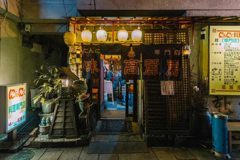 <span style="font-size:12px;">次に別府市元町の〈にんにく料理専門店 味の高麗房〉を訪れました。<br><br>店先で迎えてくださったのは、店主の山下守さん。気さくでにこやかなご主人に案内され、編集者おすすめのメニューをいただきます。<br><br>編集者のコメント： 別府にはおいしいものがたくさんあるので違う店にも行ってみたいけれど、引き寄せられるようにまた入ってしまうのが〈高麗房〉。にんにく料理専門店という看板のとおり、店内に入ると大量に吊るされたにんにくに圧倒されますが、食べ始めたらにんにくの臭いなんて気にならないおいしさ。「蒸し豚」はまず食べてほしい。何より明るくフレンドリーなお父さんとお母さんが、この店のファンを増やしていると思います。（編集者B）</span><br><br>