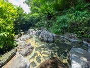大きな石を組んだ庭園風の造りと緑が風情たっぷりの大露天風呂