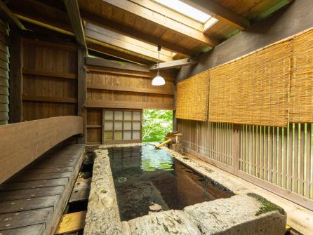 半露天付き本館客室の「雪やなぎ」。野趣あふれる石肌が風情たっぷり