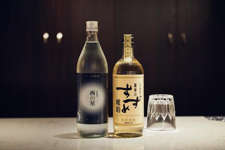 <span style="font-size:12px;"><font color="ffffff"> 写真左から〈西の星〉、〈銀座のすずめ 琥珀〉。<br> <br> 〈山崎12年〉など貴重なウイスキーもそろえるなど酒類も充実。特に大分生まれの本格麦焼酎を飲まずには帰れません。オススメは三和酒類の〈西の星〉。一般的な麦焼酎の多くは外国の小麦でつくられますが、こちらは大分県産の大麦〈ニシノホシ〉を原料に麹の技でじっくり醸しています。スッキリした香りとシルクのようになめらかな喉ごしが特徴。<br> <br> 八鹿酒造の〈銀座のすずめ 琥珀〉は、アメリカ・ケンタッキー州の蒸留所から取り寄せたバーボンウイスキーの樫樽に貯蔵した大分麦焼酎。ふくよかでスモーキーな風味に酔いしれて。</font></span><br><br>