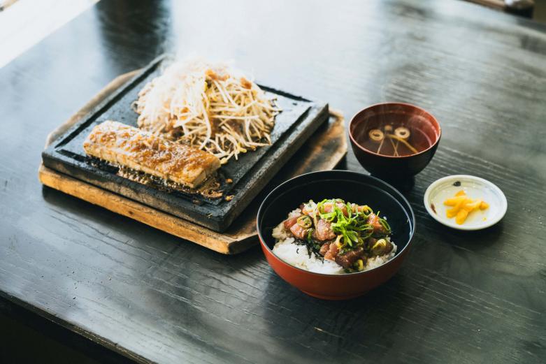 <span style="font-size:12px;"><font color="ffffff">「まぐろステーキ ひゅうが丼小盛セット」3000円。<br> <br> さて、津久見市はもうひとつ、「マグロのまち」としても知られています。津久見港から約14キロの豊後水道に浮かぶ保戸島は、明治時代から続くマグロ遠洋漁業の拠点として栄え、全国でも有数のマグロ水揚げ量を誇っていました。<br> <br> 市内にはマグロの加工場が点在し、養殖本マグロ〈豊後まぐろ ヨコヅーナ〉の産地でもあります。市内にはマグロ料理を提供する飲食店も増え、まちの新たな観光資源としても一役買っています。<br> <br> 腹が減っては夜景観賞はできぬ！　ということで、まずは市内の食事処でマグロ料理を食べるのがおすすめです。<br> <br> マグロをはじめ新鮮な魚介料理が食べられる〈浜茶屋〉の人気メニューは、郷土料理「ひゅうが丼」と、オリジナルで考案された「まぐろステーキ」。地元で知らない人はいない郷土料理ですが、そもそも「ひゅうが丼」とは？</font></span><br><br>